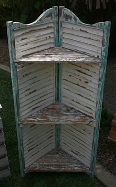 an old white painted wooden shelf in the grass