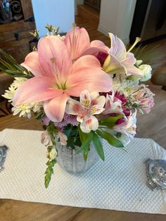 a vase filled with pink and white flowers on top of a table