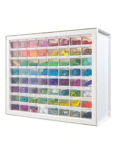 a white drawer filled with lots of crafting supplies on top of a white wall