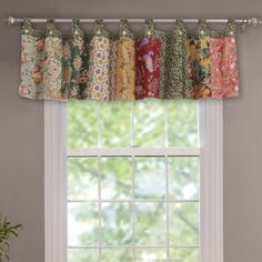 a kitchen window with an assortment of colorful curtains