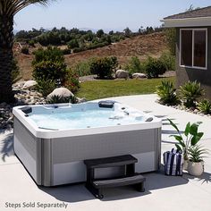 a hot tub sitting on top of a patio next to a palm tree