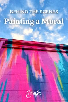 the words behind the scenes painting a mural against a blue sky with clouds in the background