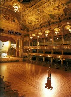 a person is standing in the middle of a large room with chandeliers on it