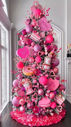 a pink christmas tree decorated with hearts and candies