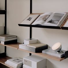 an open book sitting on top of a wooden shelf next to books and other items