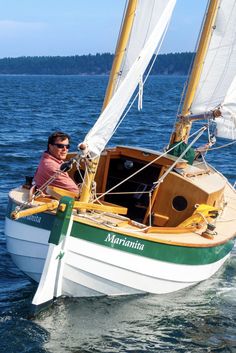 a man sitting on top of a sailboat in the ocean