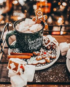 a cup filled with cookies and marshmallows on top of a table