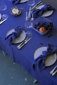 the table is set with blue linens and silverware