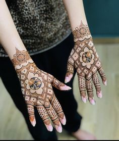 two hands with henna designs on them