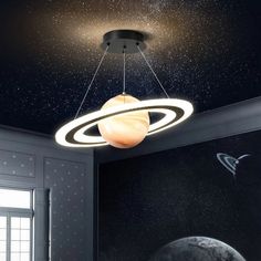 a ceiling light that is hanging from the ceiling in a room with planets and stars