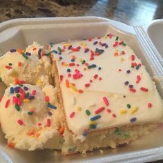 two pieces of cake with sprinkles in a foam container