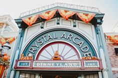 the entrance to disneyland's crystal arcade at halloween time with pumpkins hanging over it