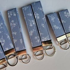 four pairs of blue and gold key chains with floral print on them, all tied together