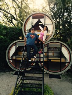 a man and woman standing on top of a set of stairs