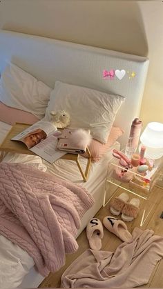 there is a bed with pink blankets and slippers on the floor next to it