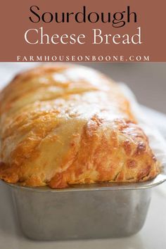 a loaf of sourdough cheese bread sitting in a pan on top of a table