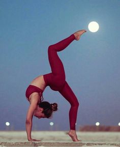 a woman is doing yoga on the beach