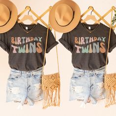 two t - shirts that say birthday twins with hats hanging on the back of them