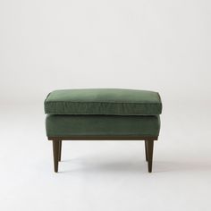 a green footstool sitting on top of a white floor