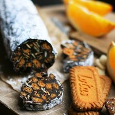 an assortment of cookies and oranges on a cutting board