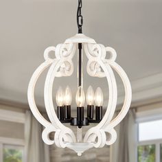 a white chandelier with three lights hanging from it's center and two candles in the middle