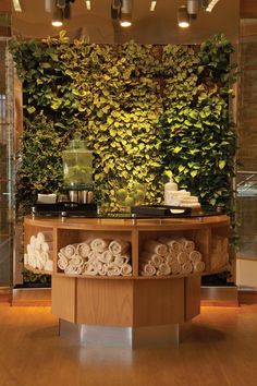 a bathroom with a green wall behind the counter and towels stacked on top of it