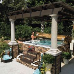 an outdoor hot tub surrounded by plants and trees