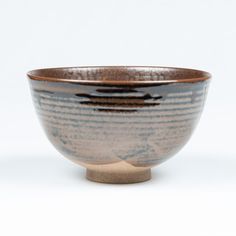 a brown and black bowl sitting on top of a white table