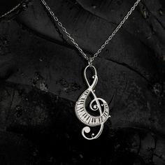 Elevate your ensemble with the timeless elegance of the Sussex Home Treble Clef Necklace. This exquisite piece is meticulously handcrafted from sterling silver and adorned with a lustrous gold plating, making it a stunning choice for any music enthusiast.

- Material: Sterling Silver, Gold Plated
- Color: Gold
- Gender: Female
- Age Group: Adult

Designed with a delicate treble clef pendant, this necklace serves as a symbol of your everlasting love for music. It's the perfect gift for bridesmaid Nickel-free Silver Music-themed Necklaces, Silver Music-themed Metal Necklace, Music-themed Metal Jewelry For Gifts, Silver Music-themed Necklace For Gift, Music-themed Silver Pendant Necklace, Silver Sterling Music-themed Necklace, Nickel-free Sterling Silver Music-themed Necklace, Music-themed Sterling Silver Necklace, Silver Music-themed Round Jewelry