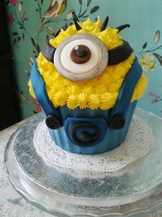 a blue and yellow cake with a minion on top