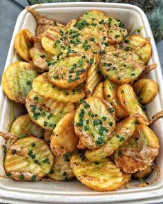 a white dish filled with fried potatoes covered in seasoning