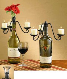 two bottles of wine sit next to each other on a table with candles in front of them