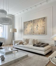 an elegant living room with white walls and flooring is furnished with modern furniture, including a large painting on the wall