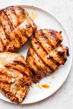 three pieces of grilled meat on a white plate