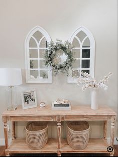 a wooden table with two baskets on top of it next to a wall mounted clock