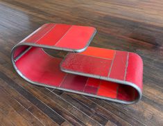 two red tables sitting on top of a wooden floor