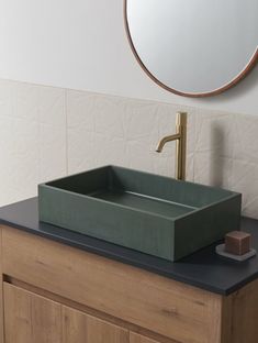 a bathroom sink sitting on top of a wooden counter next to a mirror and a faucet