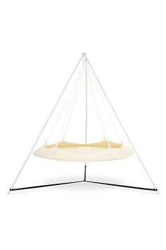 a white hammock hanging from a metal stand on top of a white wall