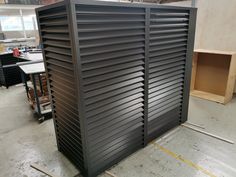 a large metal box sitting on top of a floor next to a wooden table and chair