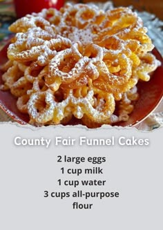 a red plate topped with funnel cakes covered in powdered sugar next to an apple