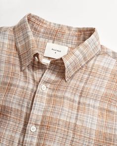 Our Wilson shirt is woven from lightweight linen in a standard fit, providing ease of movement and ultimate comfort. This version features a beautiful custom plaid designed in-house. It's constructed with a hidden button-down collar and French placket and finished with genuine smoke mother-of-pearl buttons and our signature heirloom ribbon stripe applied to the bottom of the under placket. A versatile statement piece that easily dresses up or down. This shirt is a standard fit. Model is 6'2" wea Linen Shirt Pattern, Mens Outfits Dressy, Business Casual Attire For Men, Striped Shirt Men, New Shirt Design, Check Shirt Man, British Khaki, Billy Reid, Linen Shirt Men