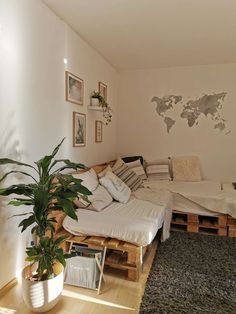 a living room filled with lots of furniture and plants on top of it's wooden pallets