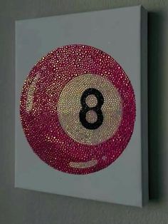 a red and white pool ball with the number eight in it's center is hanging on a wall