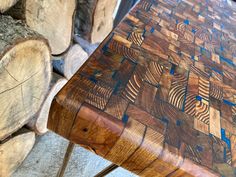 a wooden table sitting on top of a pile of firewood next to some logs