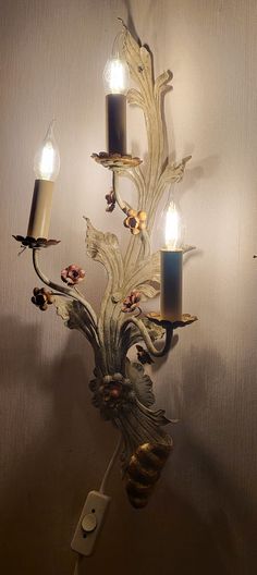 a wall mounted candle holder with three candles