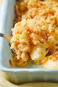 a close up of a spoon with food on it in a casserole dish