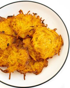 some fried food on a white plate with black trim around the edges and bottom edge