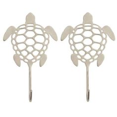 pair of sea turtle hooks in white metal with holes on each side and an oval cutout at the top