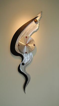 a clock that is on the side of a wall with a wave design around it