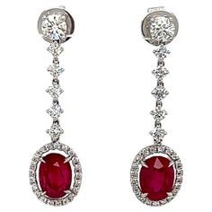 5.21 Total Carat Ruby and Diamond Drop Earrings in 18K White Gold This gorgeous pair of Ruby earrings are sure to draw all eyes on you. It is created with generous 4.03 Carats worth of Oval cut rubies, surrounded by a halo and drop decorated with round cut diamonds totaling 1.18 Carat. The stones are Prong-set securely in 18K White Gold. Wear it on its own, or with matching Ruby pendants or necklaces, the earrings will set you apart from the rest of the crowd. Specifications: -Ruby Stones: 4.03 Ruby Pendants, Ruby Pendant, Ruby Earrings, Ruby Stone, Oval Cut Diamond, Ruby Diamond, Diamond Drops, All Eyes, Diamond Drop Earrings